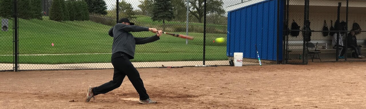 Hitting softball with bat